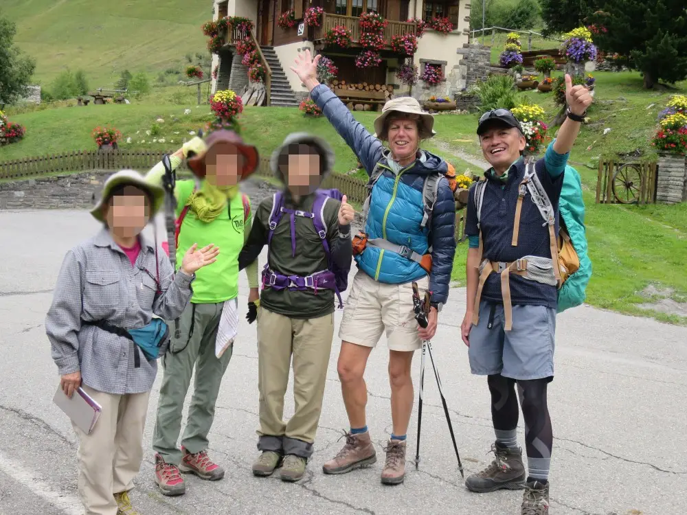 花飾りの建物の前で笑顔を見せる5人のハイキンググループ