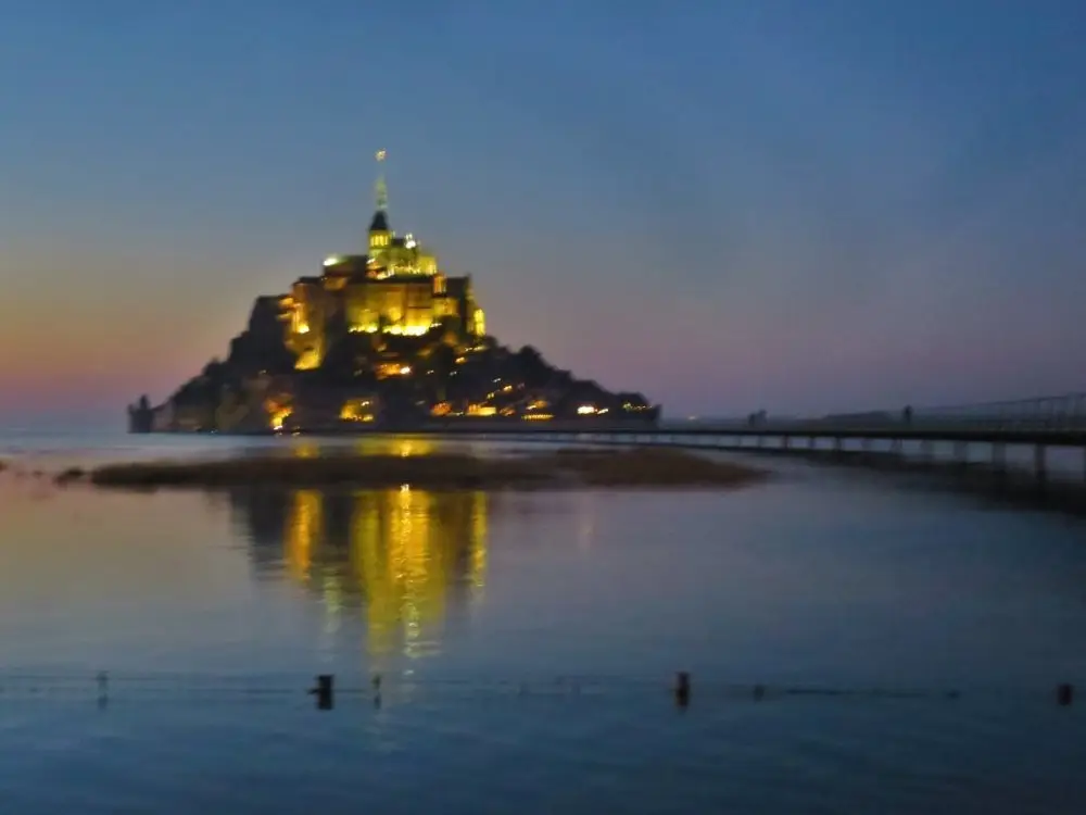 ライトアップされたモンサンミッシェルが大潮の海に映る