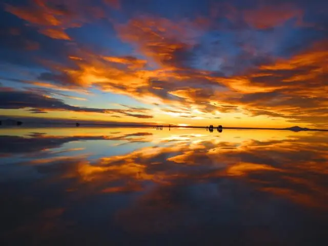 ウユニ塩湖の夕暮れ、鮮やかなオレンジ色の雲が水面に反射する