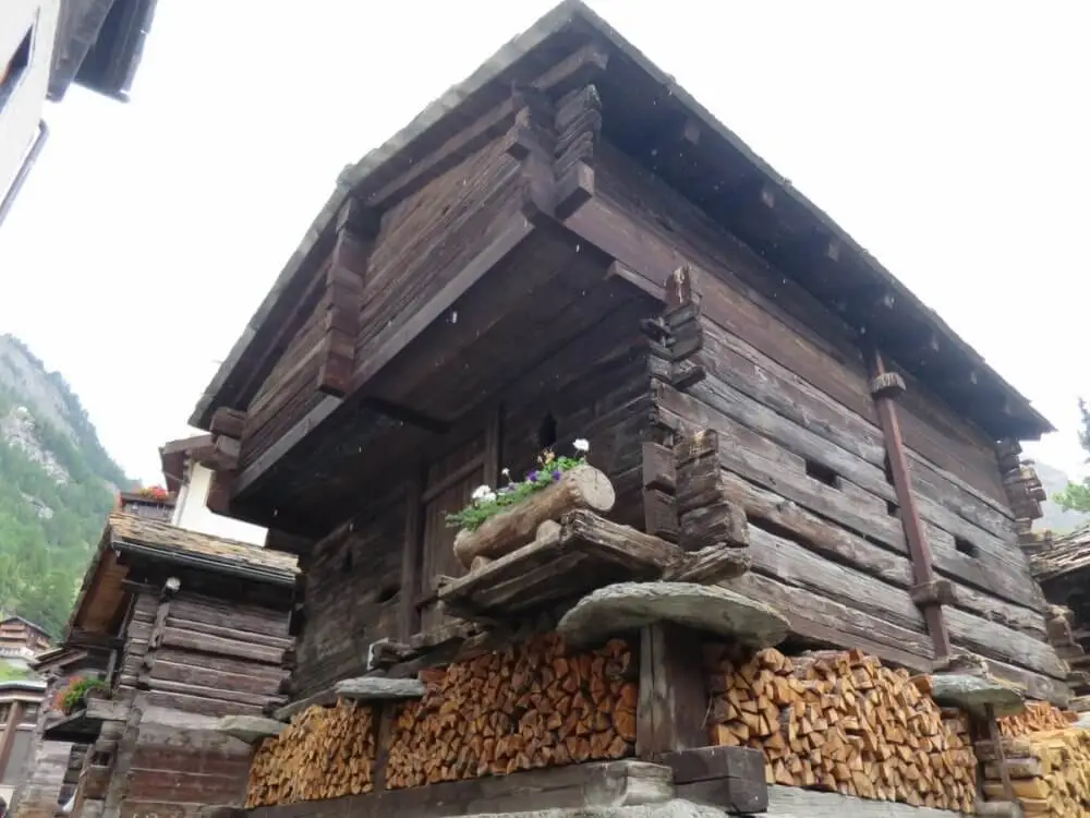 ネズミ返しのある伝統的な木造小屋と積まれた薪