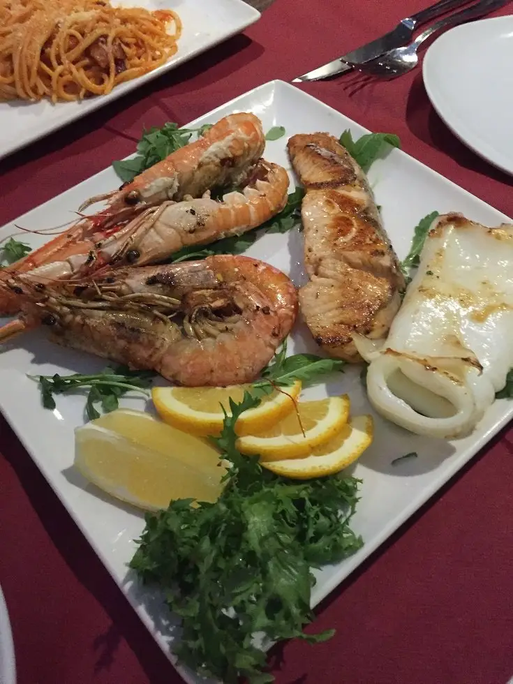 イタリア料理。エビ、イカ、魚のグリル、レモン添えのシーフード。