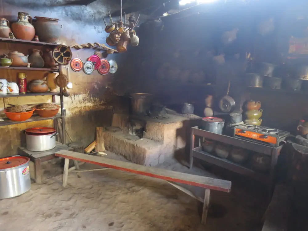 インディヘナ農家の台所。土器や鍋が並び、土間には光が差し込む。