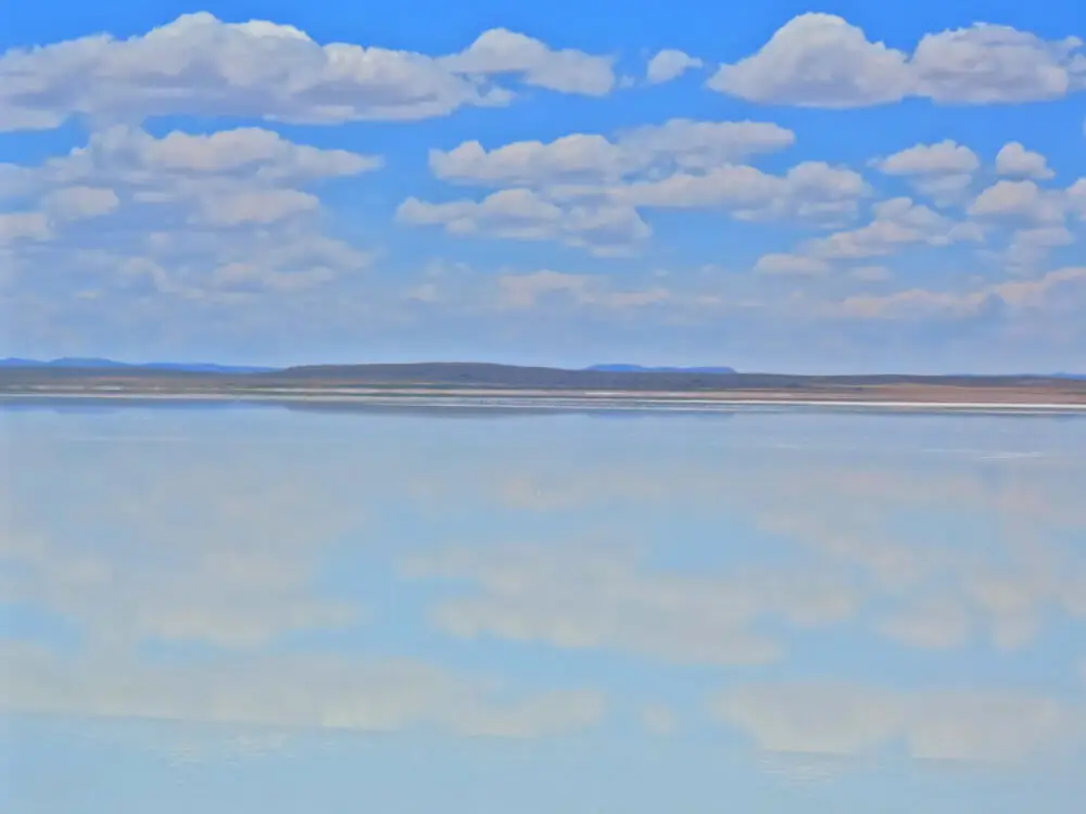 雲が映り込むウユニ塩湖の水面と青空の広がる風景