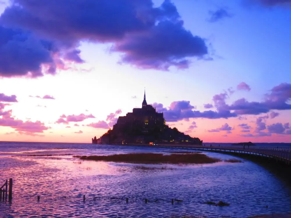 夕暮れの空と海を背景にライトアップされたモンサンミッシェル