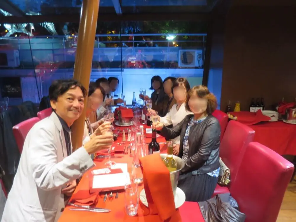 船内でシャンパングラスを掲げ笑顔で乾杯する人々