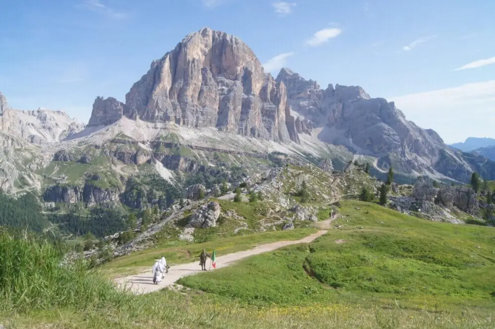 ドロミテのトファーナ山。緑豊かな丘陵が広がり、ハイキング客が見える。