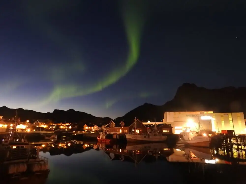 ノルウェーのスボルベルの港町、夜空に緑のオーロラが広がる