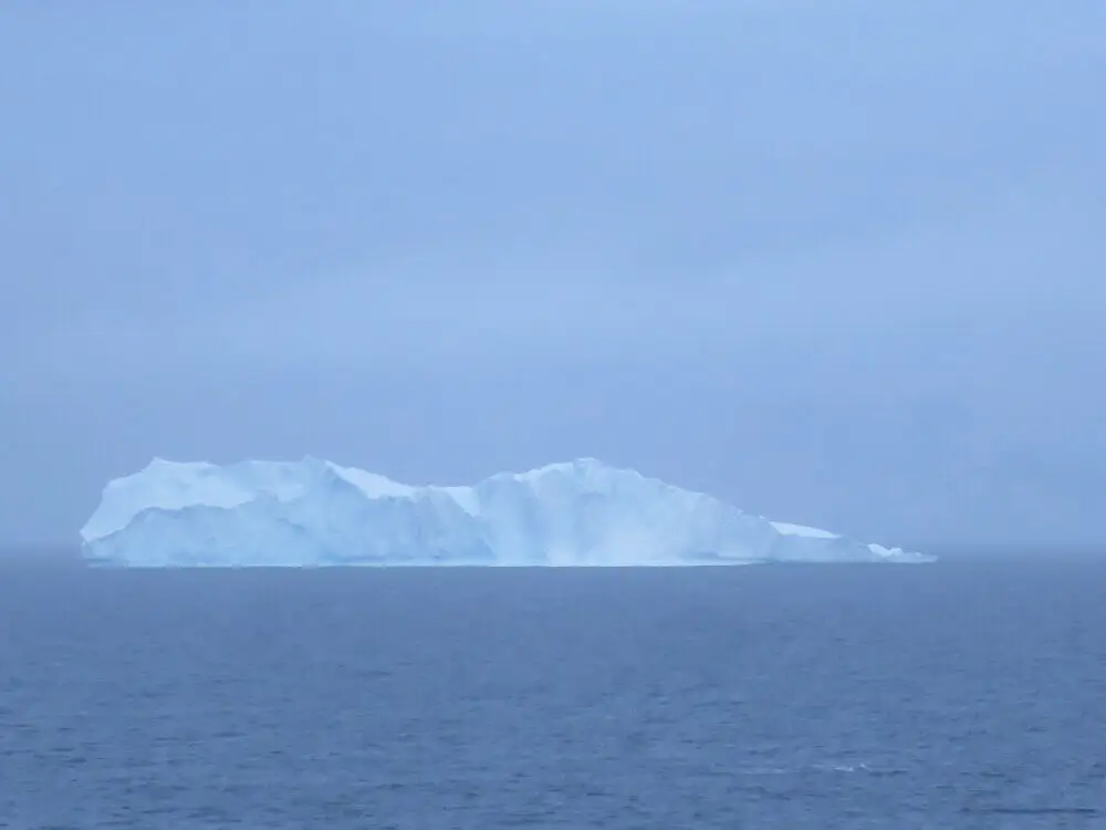 霧に包まれた洋上に浮かぶ巨大な氷山
