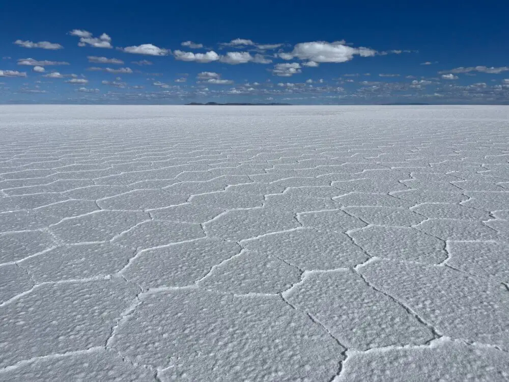 乾季のウユニ塩湖、白い塩の結晶が広がる広大な大地と青い空。