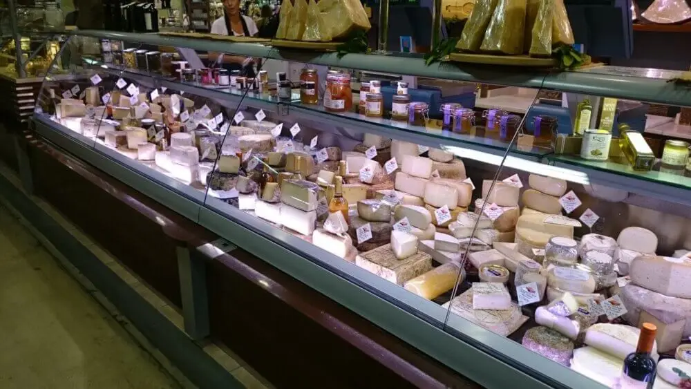 冷蔵ケースに並べられた、様々な種類のイタリア産チーズと食品。