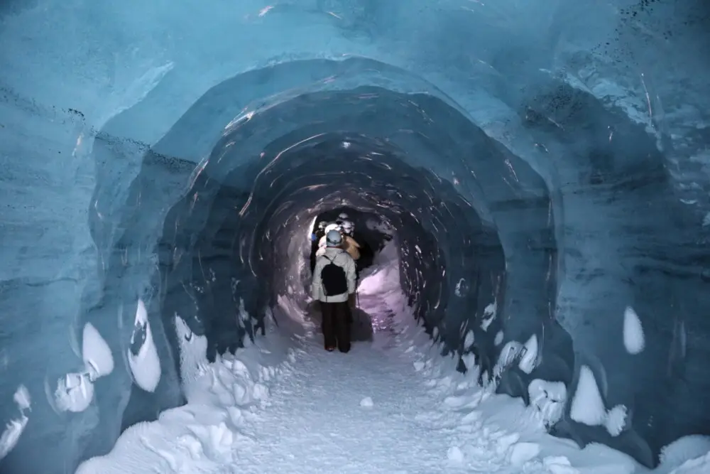 カトラトラックの氷のトンネルを奥へと進む一人の観光客。