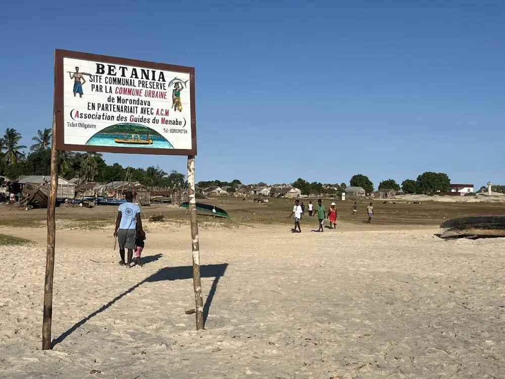 ヴェタニアの標識と乾いた砂地を行き交う人々