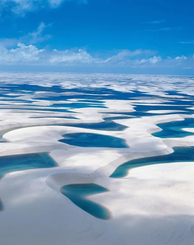 レンソイスの白い砂丘と青い湖が広がる空撮風景。