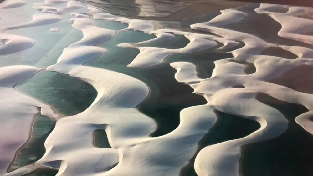 レンソイスの白い砂丘と緑色の湖が広がる空撮。
