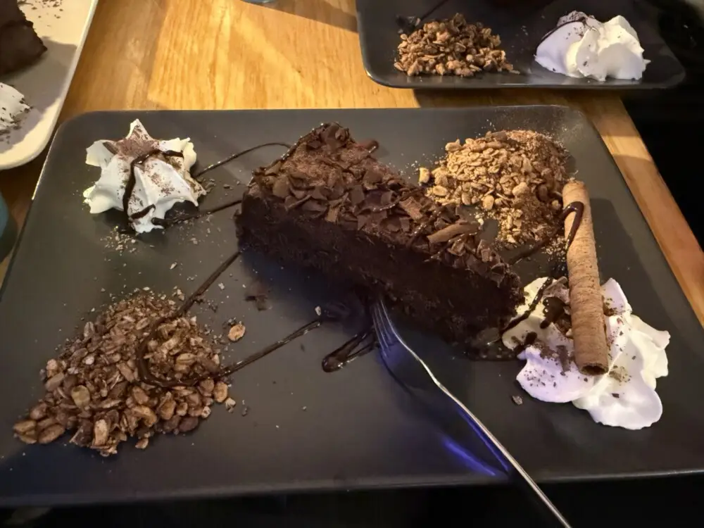 チョコレートケーキがホイップとクランブルと共に飾られています。