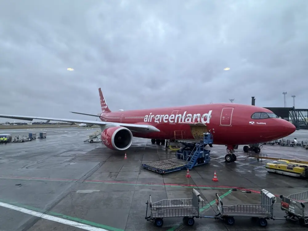 エアーグリーンランドの赤い旅客機とタラップ車が駐機する空港の様子