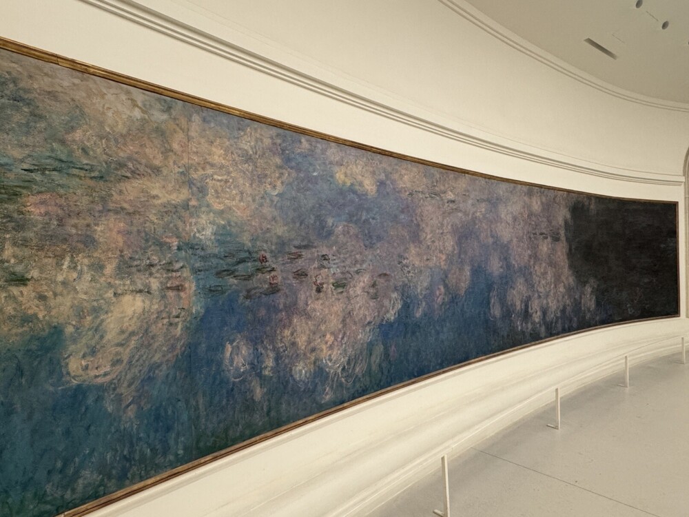 モネの「睡蓮」の巨大な絵画がカーブした壁に展示されている様子